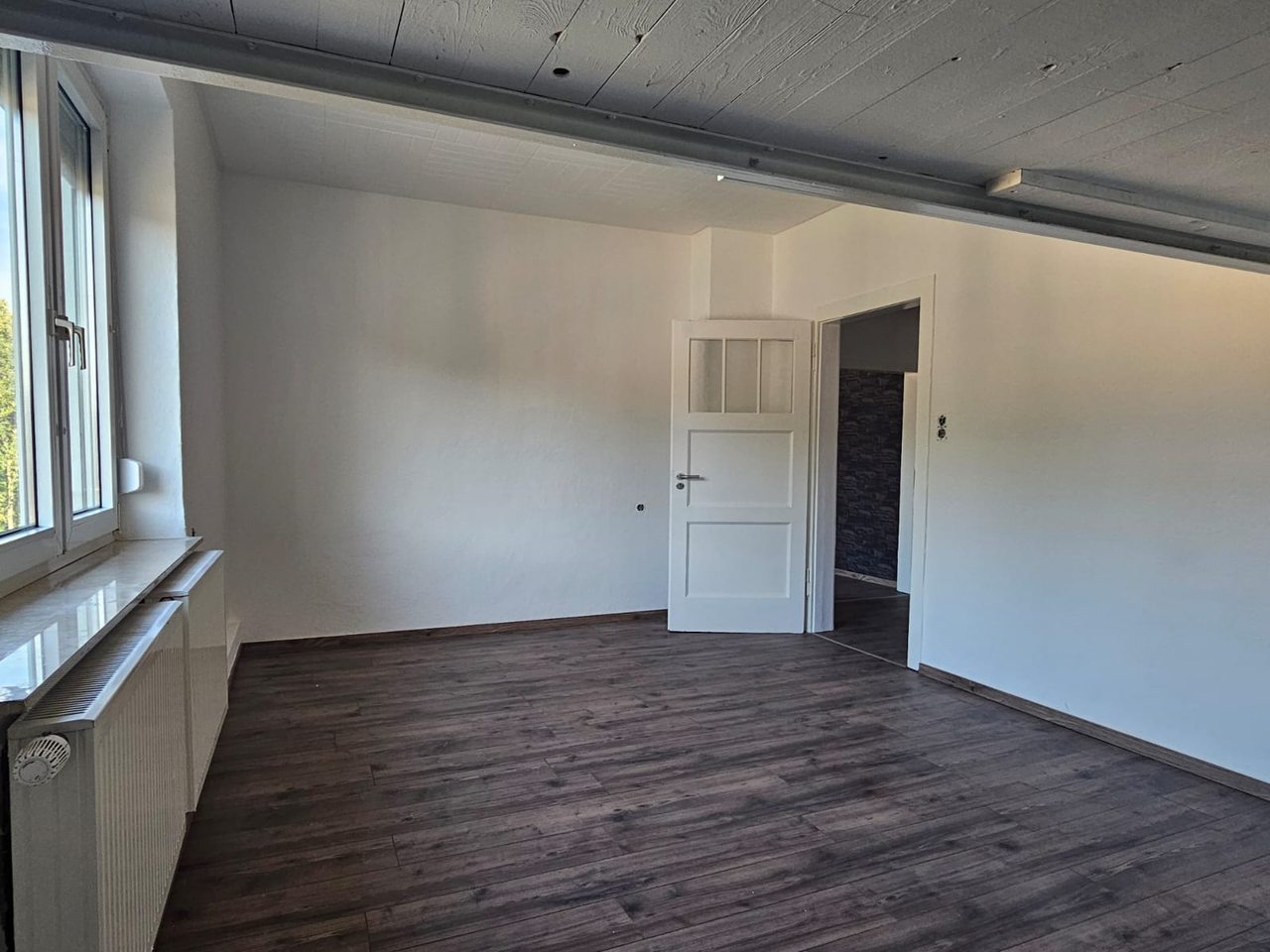 Renoviertes Schlafzimmer mit hellen Wänden und neuem Boden – eine Arbeit von Reno&In